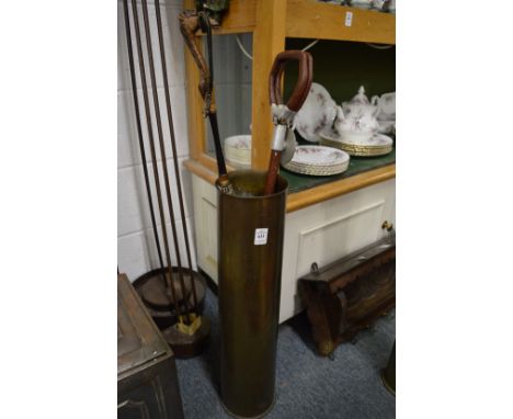 A brass shell case containing parasol and shooting stick.