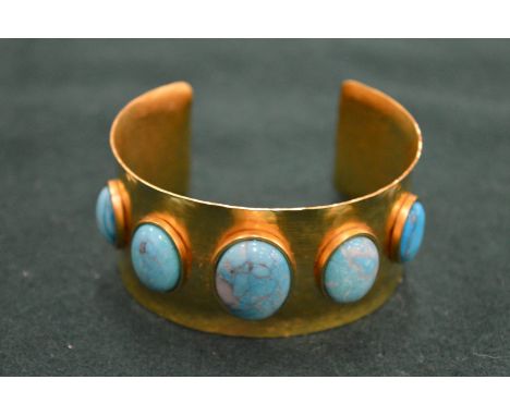 A gilt metal and turquoise inset bangle.