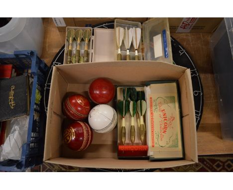 A dartboard, old darts and cricket balls.