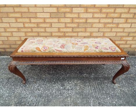 An upholstered bench seat with carved detailing, approximately 48 cm x 130 cm x 55 cm.