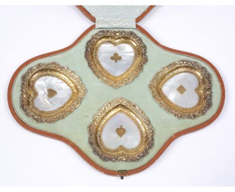 A set of four heart-shaped silver gilt dishes with pierced and embossed decoration and set with playing card suits, Birmingha