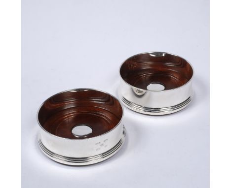 A pair of modern silver wine coasters of plain form with turned mahogany bases, in original presentation boxes, by Broadway S