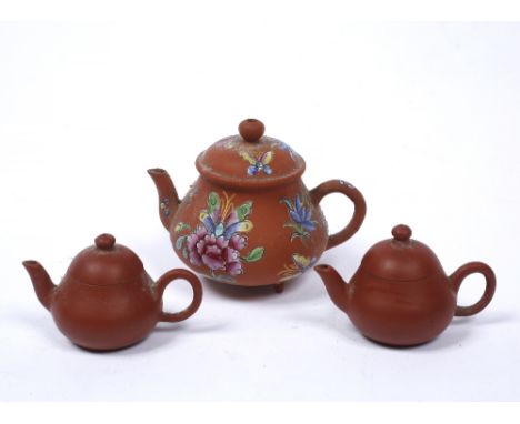 A Chinese Yixing miniature teapot with painted enamel decoration and a pair of miniature Yixing teapots (3)