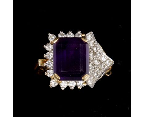 An 18ct gold ring with stylised central amethyst surrounded by diamond setting