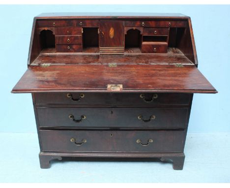 An 18th century mahogany bureau with conche-shell inlaid sloped front enclosing pigeonholes and drawers, above two short and 