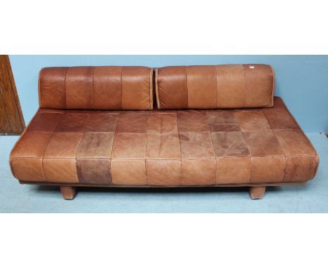 A retro day bed with tan leather upholstery and back rest cushions for use as a sofa. 198cm long.