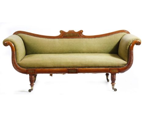 λ A Regency mahogany sofa, decorated with rosewood and brass marquetry panels, with scroll ends and on ribbed tapering legs a