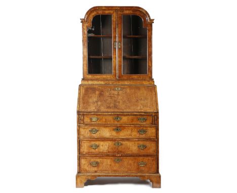 An early 18th century walnut bureau bookcase, the associated top with an arched cornice above a pair of glazed doors enclosin