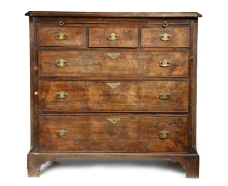 A walnut chest, the crossbanded top with a moulded edge, above a brushing slide, with three short drawers and three graduated