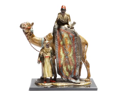 A cold painted metal orientalist table lighter, modelled with two Arabs showing a carpet, one riding a camel, mounted on a bl