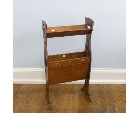 An Arts &amp; Crafts oak floor-standing two tier Book Trough/Magazine Stand, with heart-shaped pierced handles, raised on swe