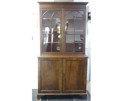 A George III mahogany astragal glazed Bookcase, the moulded cornice above two glazed doors, enclosing shelved interior, upon 