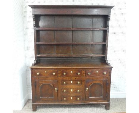 A George III Oak Anglesey Dresser Base, with six drawers and two cupboards, all having ivory escutcheons and brass handles, t