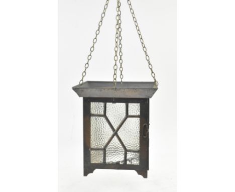An Arts &amp; Crafts early 20th century copper toned metal and textured glass lantern porch hanging light. The light having a