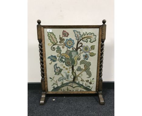 An early twentieth century oak barley twist tapestry fire screen