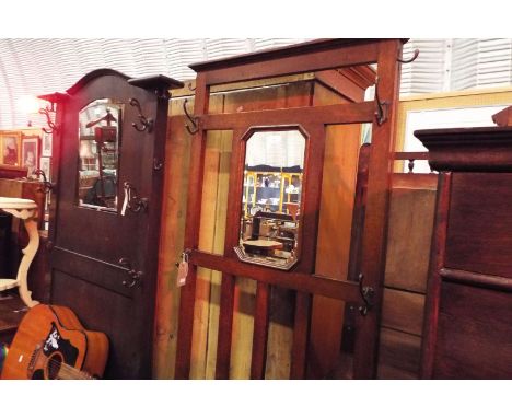 A mid-20thC oak hall stand with slatted back with central octagonal mirror over a hinged seat, flanked by a pair of stick sta