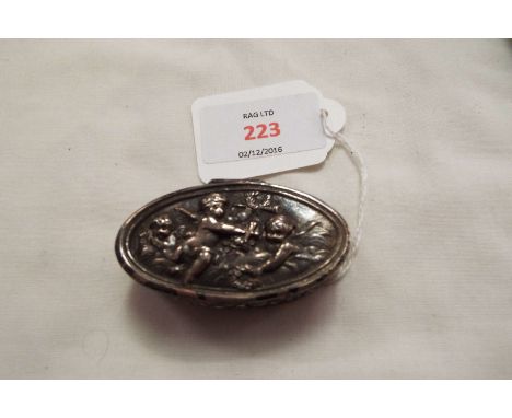 A Dutch silver patch box having putti decoration to the lid enclosing a gilded interior with trumpets and lyre decoration to 