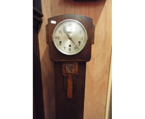 A 1920s/30s oak cased grandmother clock with silvered dial and numerals over a floral panelled trunk 