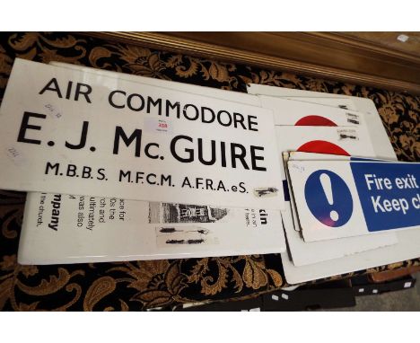 A 1960s door sign for Air Commodore E.J. McGuire, M:B:B.S., M.F:C:M, A.F.R.A.eS, together with three enamel fire exit signs a