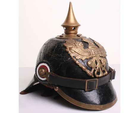 Imperial German 1887 Pattern Pickelhaube of leather shell with brass Prussian eagle helmet plate (damaged), brass spike, bras