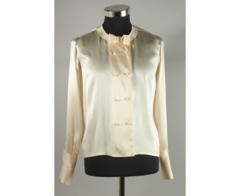 A CHANEL CREAM SILK BLOUSE with pearl style double C buttons and bow. Size 40