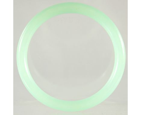 AN ICY CELADON JADE BANGLE. 3ins diameter.