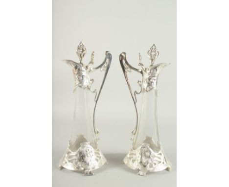 A GOOD PAIR OF W. M. F. PLATE AND GLASS CLARET JUGS 17ins high.