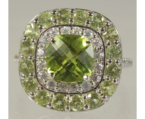 A 9CT WHITE GOLD DIAMOND AND PERIDOT RING.