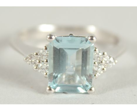 AN 18 CARAT WHITE GOLD HALLMARKED OCTAGONAL AQUAMARINE AND DIAMOND RING.