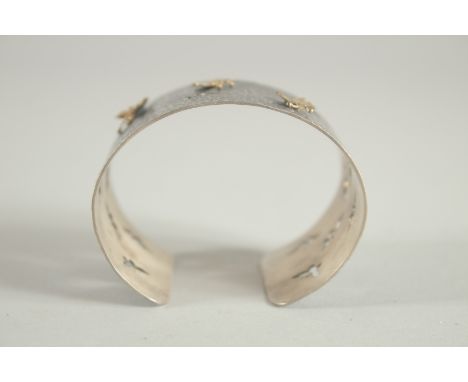 A HALLMARKED STERLING SILVER OXIDISED HAMMERED BANGLE, mounted with gilded butterflies.