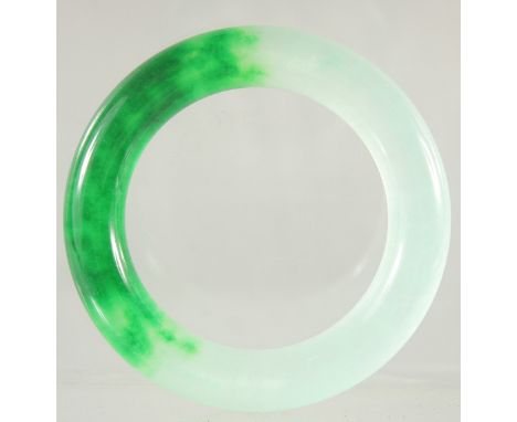 A HEAVY TWO TONE JADE BANGLE.