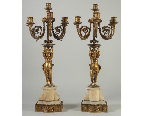 A GOOD PAIR OF 19TH CENTURY ORMOLU AND ONYX FIVE BRANCH, SIX LIGHT CANDELABRAS, the ornate scrolling branches held aloft by s