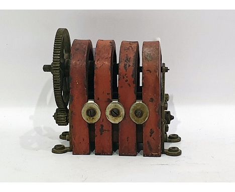 Early 20th century table-top mounted electric engine having cast iron arched top, housing brass-mounted wheel turned by two c