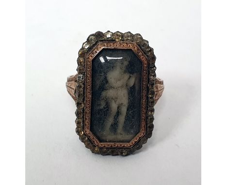 Georgian ring of shaped rectangular form, set with an enamel of a child under a glazed cover, bordered by paste and with engr