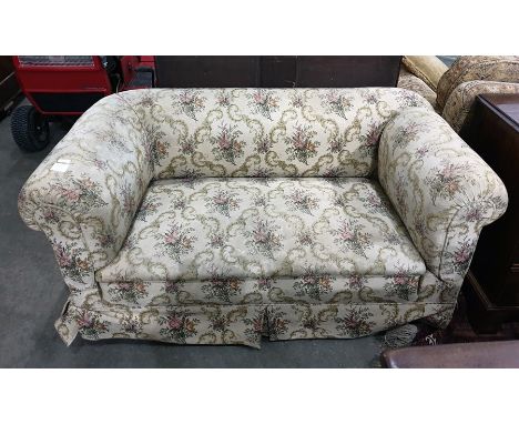 19th century Chesterfield-type drop arm sofa in beige ground foliate patterned upholstery, raised upon turned supports to bla