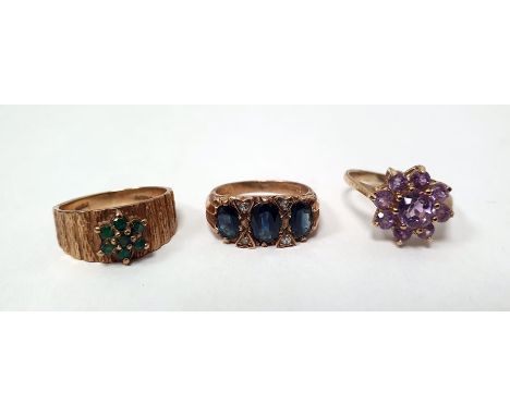 9ct gold band ring with textured decoration set with a small emerald seven-stone cluster, a 9ct gold and amethyst cluster rin