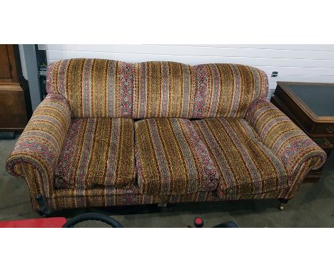 George Smith three-seat sofa in the manner of Howard, vibrantly upholstered, raised upon turned supports to brass caps and ca