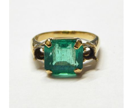 18ct gold ring set with large square cut emerald to the centre, the shoulders with settings for two further stones (missing) 