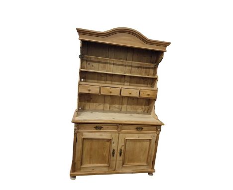 Old pine dresser with arched pediment, open shelf plate rack with four spice drawers, pair of frieze drawers below, panelled 