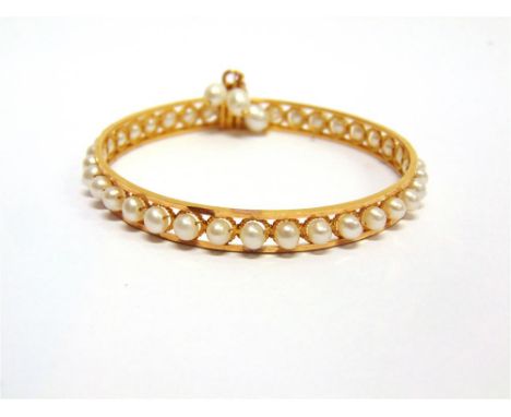 A CONTINENTAL FRESHWATER CULTURED PEARL SET BANGLE unmarked, the thirty five pearls to a stiff bangle with screw clasp from w