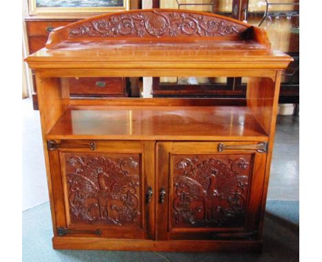 AN EDWARDIAN CARVED WALNUT BUFFET,  the doors carved with peacocks and with strap hinges in the Arts and Crafts taste, metal 