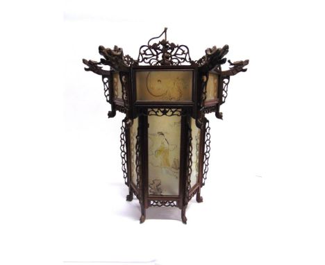 AN ORIENTAL HANGING LANTERN , of hexagonal form, the hardwood frame with open fretwork carving and decorated with carved drag