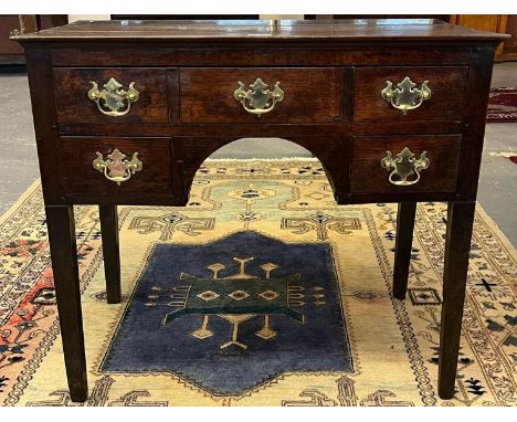 18th century Welsh oak lowboy, the plain plank top above an arrangement of one long and two short drawers, around central arc