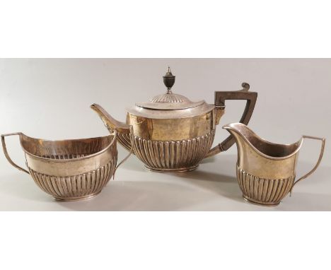 Edward VII silver three piece tea service, of fluted form, with ebonised handle and finial to the teapot. Comprising teapot, 