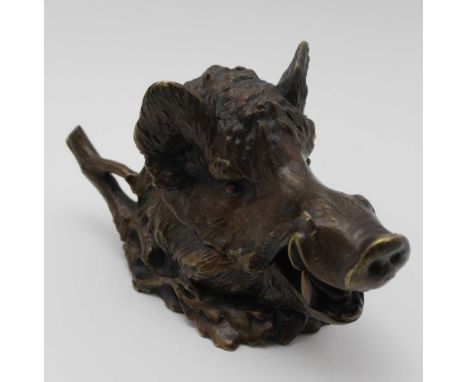 A late 19th century bronze boars head desk inkwell, having pen rest to the back, head hinges open to reveal a ceramic inkwell
