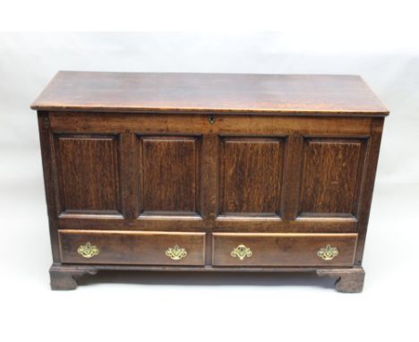 A 18th century oak mule chest having plain lift up lid over four plain panel frontage, two in-line drawers below supported on