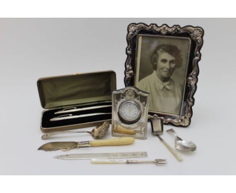 A George III silver caddy spoon, Birmingham 1801, together with various silver wares including a silver mounted travel clock,