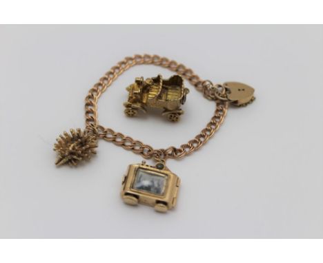 A 9ct gold charm bracelet with padlock clasp, a 9ct gold hedgehog charm, a stanhope camera charm, and a yellow metal car char