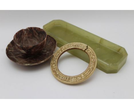 A 19th century carved ivory bangle with Middle Eastern script in the round 10.5cm in diameter, together with a carved green s