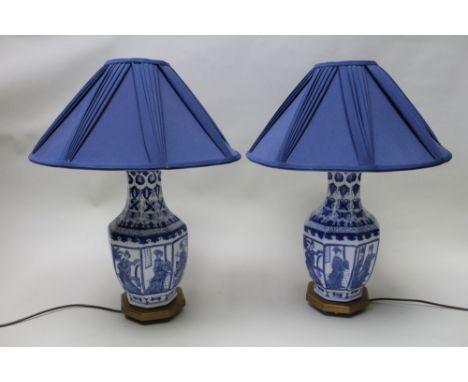 A pair of table lamps, the bodies styled as Chinese porcelain vases, printed in cobalt blue with Bijin panels, raised on gild